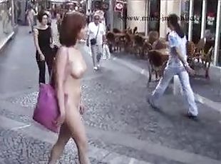 Redhead walking down a European street nude
