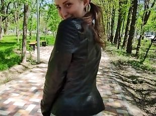 Schoolgirl with big eyes walks in the park after school in a leather jacket