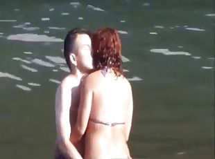Horny couple having fun in the water at the beach