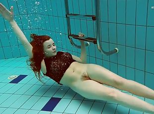 Hot Russian redhead Vesta enjoys swimming around the pool naked